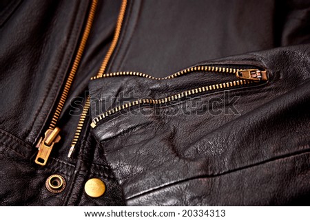 detail of sleeve and brass zippers of leather jacket