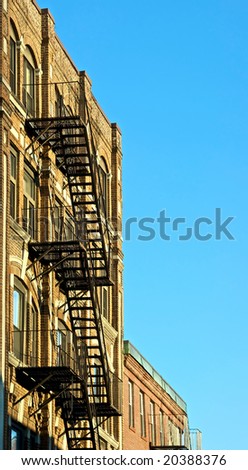 fire escapes on old tenement buildings in boston massachusetts against a blue sky