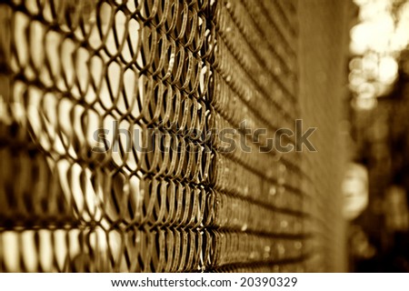 shallow depth of field in this abstract  chain link fence image finished in sepia