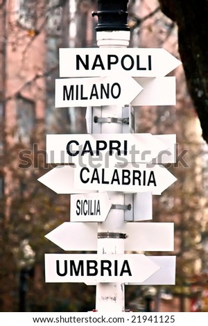 signs pointing in all directions to various Italian cities