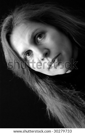 portrait of pretty female with long hair in black and white big eyes and full lips. side lighting