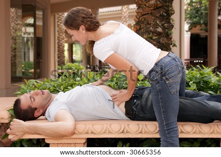 attractive young lady getting ready to massage her man\'s chest at tropical resort