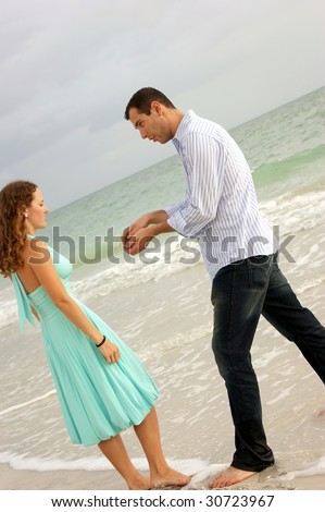 man pretending to propose to woman on bonita beach in florida