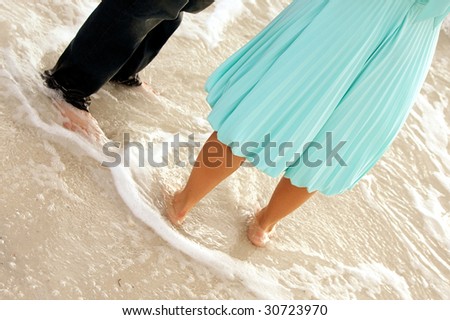 funny image of two well dress people standing in the ocean, showing from the waist down