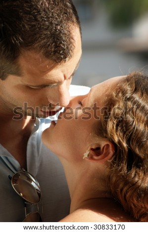 close up of sexy young couple about to kiss in the hot afternoon sunshine with their lips parted ready to meet