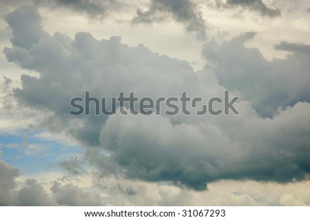 A large cumulus cloud dominates the scene as it moves in front of light wispy ones in the background