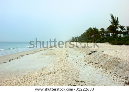 Looking down Bonita beach in Bonita Springs Florida on an early morning, fog is still in the distance.