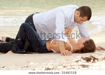 stock photo A beautiful young couple on the beach in wet clothes 