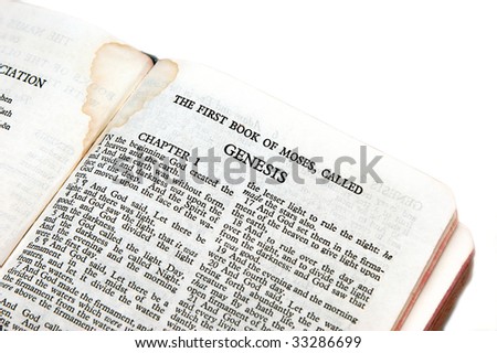 holy bible open to the first book of moses called genesis, on white