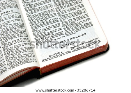 holy bible open to the third book of moses called leviticus, on white