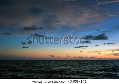 a colorful sunset creates the backdrop for this scene of the gulf of mexico