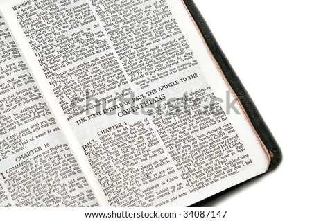holy bible open to the first epistle of paul the apostle to the corinthians, against a white background