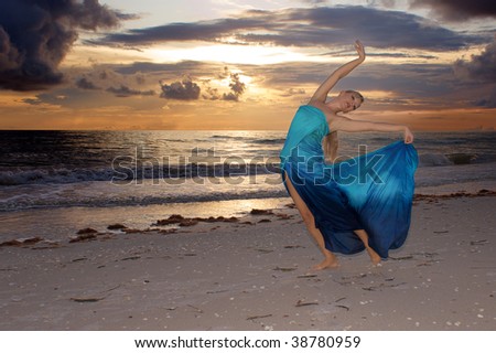 an attractive blonde female dancer on the beach at sunset in pose that makes her look like an artist\'s muse.