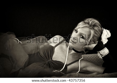 woman in old fashioned sexy outfit laying down looking at viewer, finished in sepia.