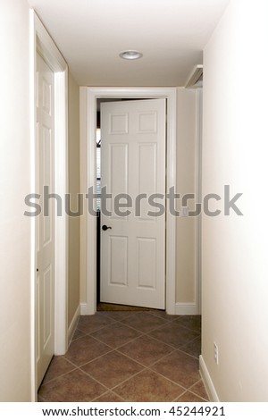a door at the end of a hallway is slightly open