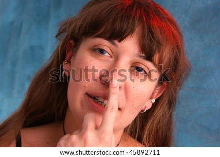 a beautiful woman is touching her nose as if taking sobriety test, shot with red and blue strobes to enhance colors.