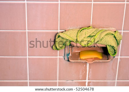 soap scum covers all the visible tiles, mold can be seen on the soap holder and wash cloth