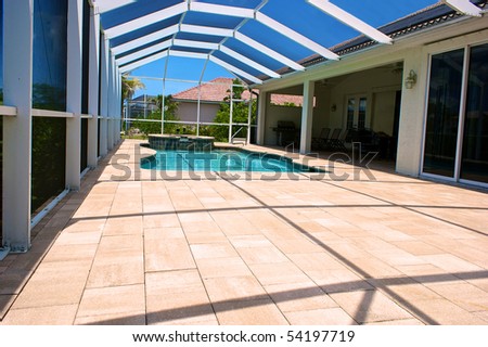wide angle view of screened in pool and lanai in florida with blue sky