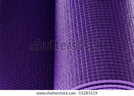 close up of a rolled up yoga or pilates exercise mat isolated on white.