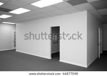 view of a room inside of a room with blank walls and open doors in a vacant office building