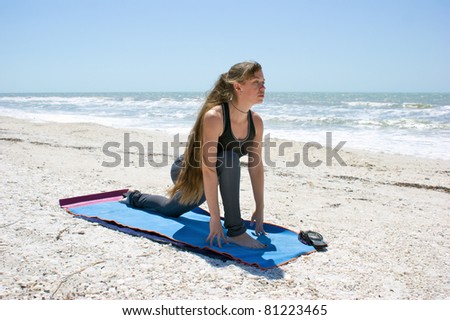 woman doing yoga exercise woman doing yoga exercise  Salamba Kapotasana or Supported Pigeon Pose on an empty beach at the gulf of mexico in bonita springs floridawith long hair blowing in wind