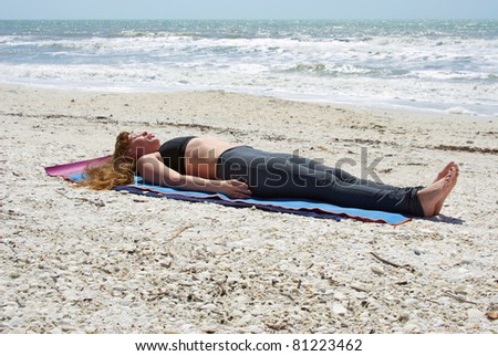 woman doing yoga exercise woman doing yoga exercise  Salamba Kapotasana or Supported Pigeon Pose on an empty beach at the gulf of mexico in bonita springs floridawith long hair blowing in wind