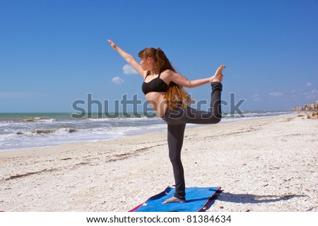 an athletic brown haired woman is doing yoga exercise dancer pose on an empty beach at the gulf of mexico in bonita springs florida
