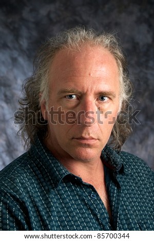A handsome mature white american male wearing casual dress shirt looking at viewer.