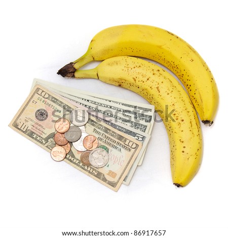 Fresh ripe bananas on white with US currency, dollars and coins, as a concept for the rising cost of commodities, inflation, rising food costs, hunger.