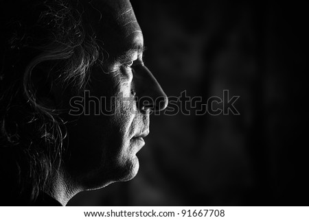 Black and white profile portrait of older white male with side lighting.