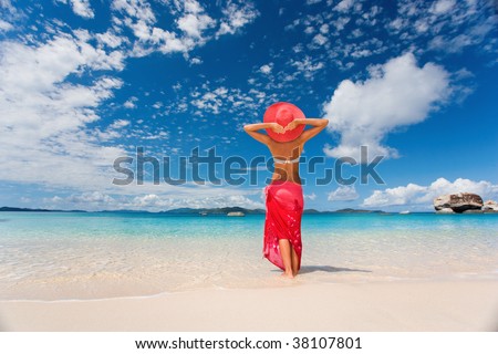 woman in red sarong on tropical beach on caribbean vacation at spring bay