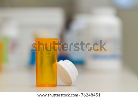 pharmacy vial, empty, in a pharmacy, stock bottles in the background