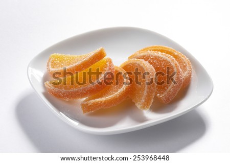 Fruit jelly heap on the white plate isolated over grey background macro shot