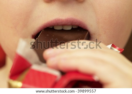 Child eating a chocolate bar macro shot