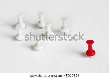 Flock of white push-pins with a red one as a leader