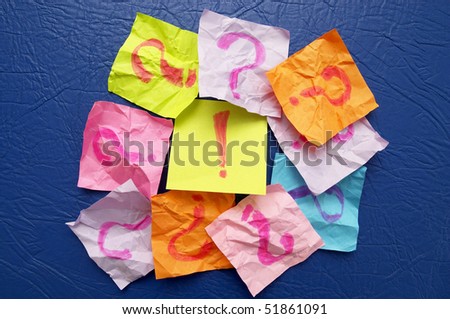 Sticker notes with exclamation and question signs over blue leather background