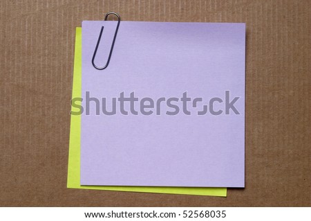Colored sticker note with metal clip on cardboard