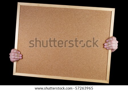 Empty office cork notice board in the hands isolated over black background