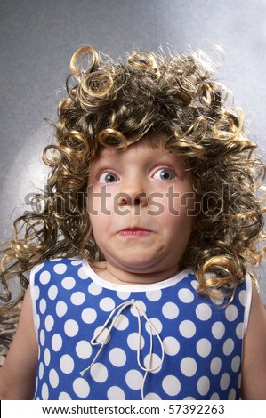 Surprised strange funny little girl in the wig (wide angle lens shot)