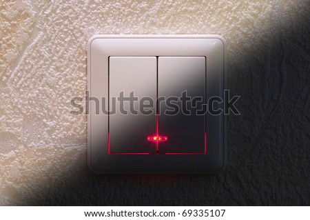 Two kinds of light switch over textured wallpaper