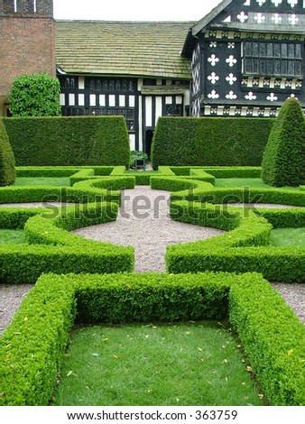 An English knot garden with a half timbered manor house in the background
