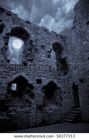 A very spooky castle in the moonlight, the moon is shining through a window.