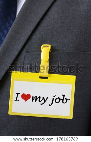 I love my job sign on name card hanging on a dark business suit