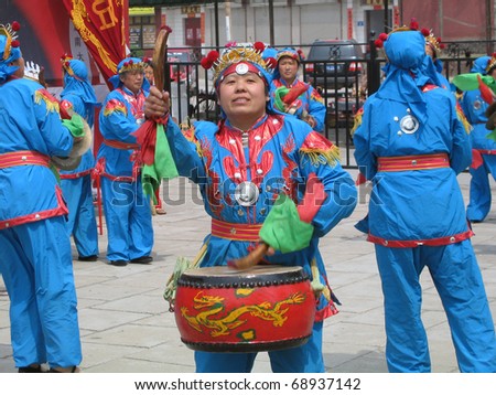 SHIJIAZHUANG, CHINA - APRIL 4: Chinese dancers with traditional drums perform in front of a temple during a folk festival in the city of  Shijiazhuang, China, on April 4, 2008.