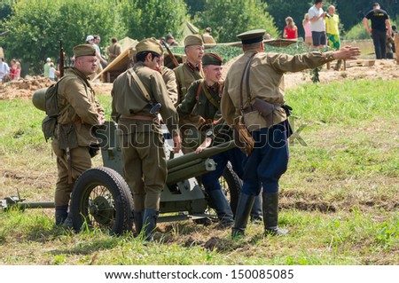 DUBOSEKOVO, RUSSIA - JULY 13: military history club members in Red Army artillery uniform deploy a field cannon during Field of Battle military history festival on July 13, 2013 in Dubosekovo, Russia