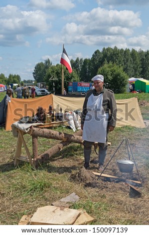 DUBOSEKOVO, RUSSIA - JULY 13: a cook stands in WWI Germany reenactors\' camp during Field of Battle military history festival on July 13, 2013 in Dubosekovo, Russia
