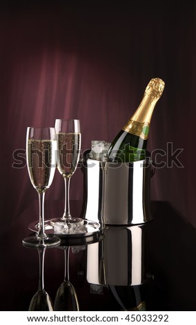 Two glasses and champagne bottle in bucket for ice stand on glass table