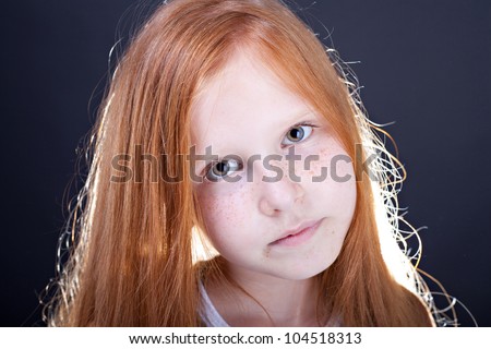 Portrait of a red haired girl on dark background