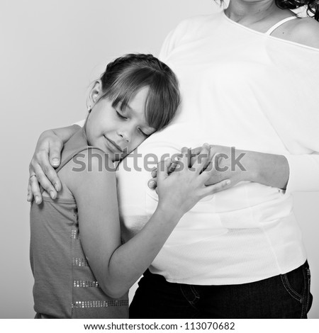 Pregnant woman with her daughter studio shooting. black-white image