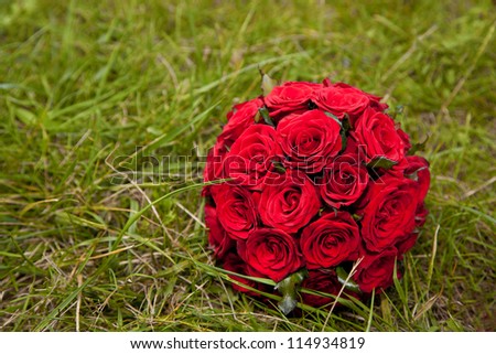 Red roses-wedding bouquet on green grass